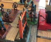 A collection of German and British made tinplate steam workshop toys dating from approximately the 1930&#39;s to the 1950&#39;s, manufactured by Marklin, Bremner Garret, Arnold, Fleischmann and Wilesco, mounted on large wooden board and driven by a superheated twin-cylinder Mamod SE3.