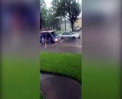Video taken in front of a house during storm Imelda shows two women pushing a stalled out car in the middle of the street during epic flooding.